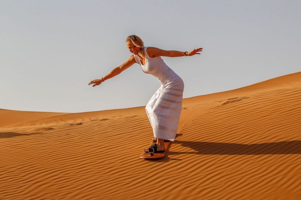 Sandboarding in Dubai Desert Caucasian Lady